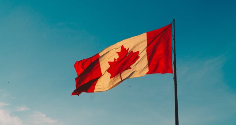 The Canadian flag flying against a blue sky